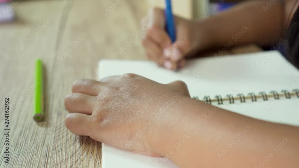 Close up of hand a little girl while her writing and drawing. Doing homeworks at home. Close up of hand a little girl while her writing and drawing. Doing homeworks at home.