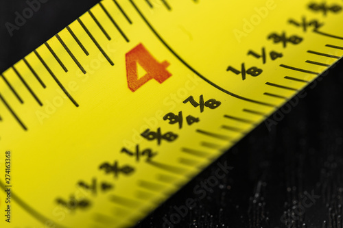 A macro image of a yellow Tape Measure