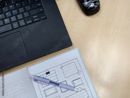 Top view office table desk with laptop, notebook, pen with copy space on wood background.