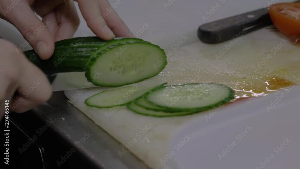 Slicing a telegraph cucumber during food preparation.