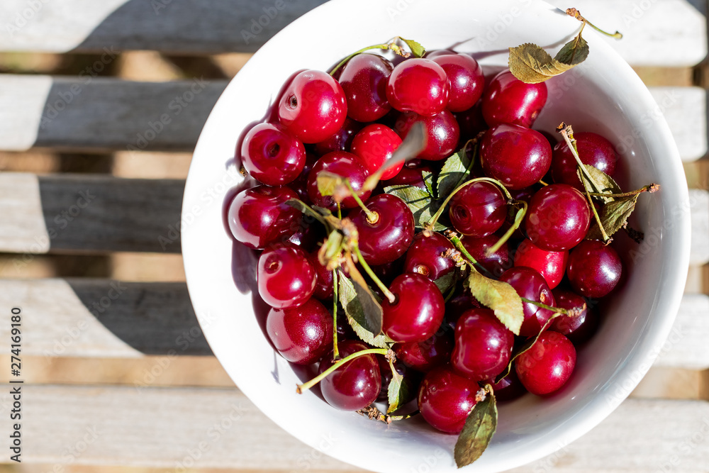 fresh cherry berries in white bowls close-up. background with berries. Organic ripe red cherry berries on wooden background.sweet cherries in garden. fresh cherry berries in white bowls close-up. background with berries. Organic ripe red cherry berries on wooden background.sweet cherries in garden.