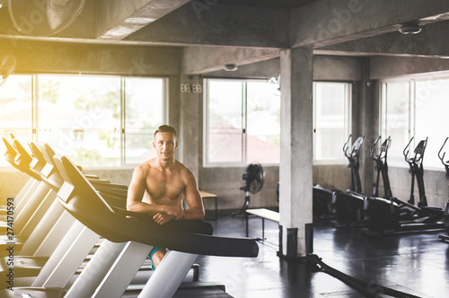 Fit man standing and smiling relax after the training session in gym,Concept healthy and lifestyle,Male taking a break after exercise and workout