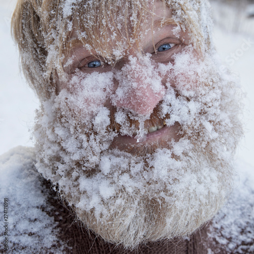 Bearded cheerful man in the winter forest.