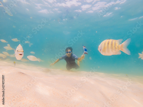Happy man in snorkeling mask dive underwater with tropical fishes with thailand flag in coral reef sea pool. Travel lifestyle, water sport outdoor adventure, swimming lessons on summer beach holiday