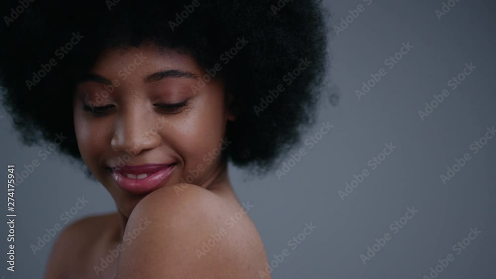 Close-up portrait of elegant pretty african girl smiling and flirting on camera. Attractive black girl with naked shoulders isolated on dark background. Close-up portrait of elegant pretty african girl smiling and flirting on camera. Attractive black girl with naked shoulders isolated on dark background.