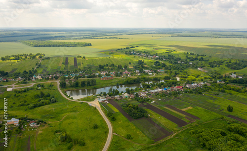 View from the quadcopter to the village with a pond and a Church near the pond © Игорь Кляхин