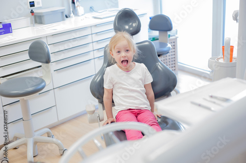 cheerful little girl in the dental chair. control at the dentist.