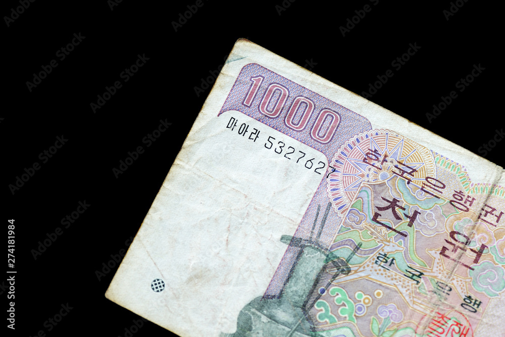 Outdated 1000 Korean Won note of 1983 issued on a black background close-up Outdated 1000 Korean Won note of 1983 issued on a black background close-up