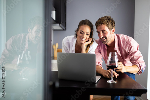 Happy smiling couple using laptop at home