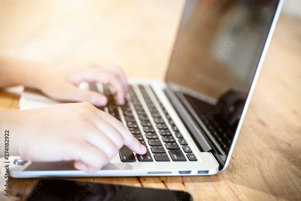 Close-up of business female working with laptop and smartphone in coffee shop like the background Close-up of business female working with laptop and smartphone in coffee shop like the background