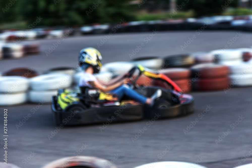 Strong motion blur karting. The picture is out of focus. Racers on races on special safe high-speed tracks limited by car tires. Attraction High-speed ride in carts. Sport karting entertainment