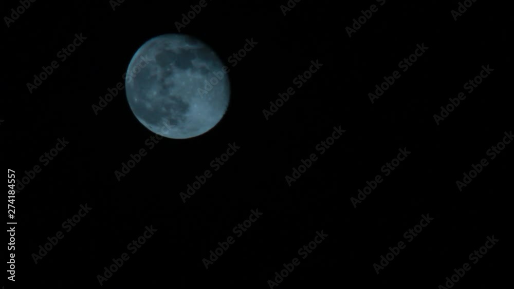 midshot of Full Moon rising at night midshot of Full Moon rising at night