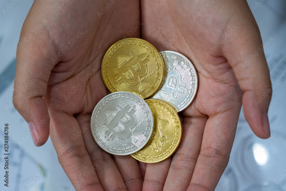 Gold and silver Bitcoins holding in hand, virtual manry and cryptocurrency concept. Gold and silver Bitcoins holding in hand, virtual manry and cryptocurrency concept.