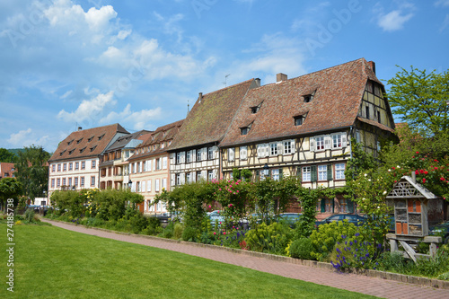 Small park with view on beautiful traditional old European style timber framing houses in city center on sunny day in Wissembourg in France