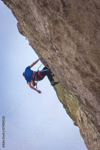 Man climbs rock.