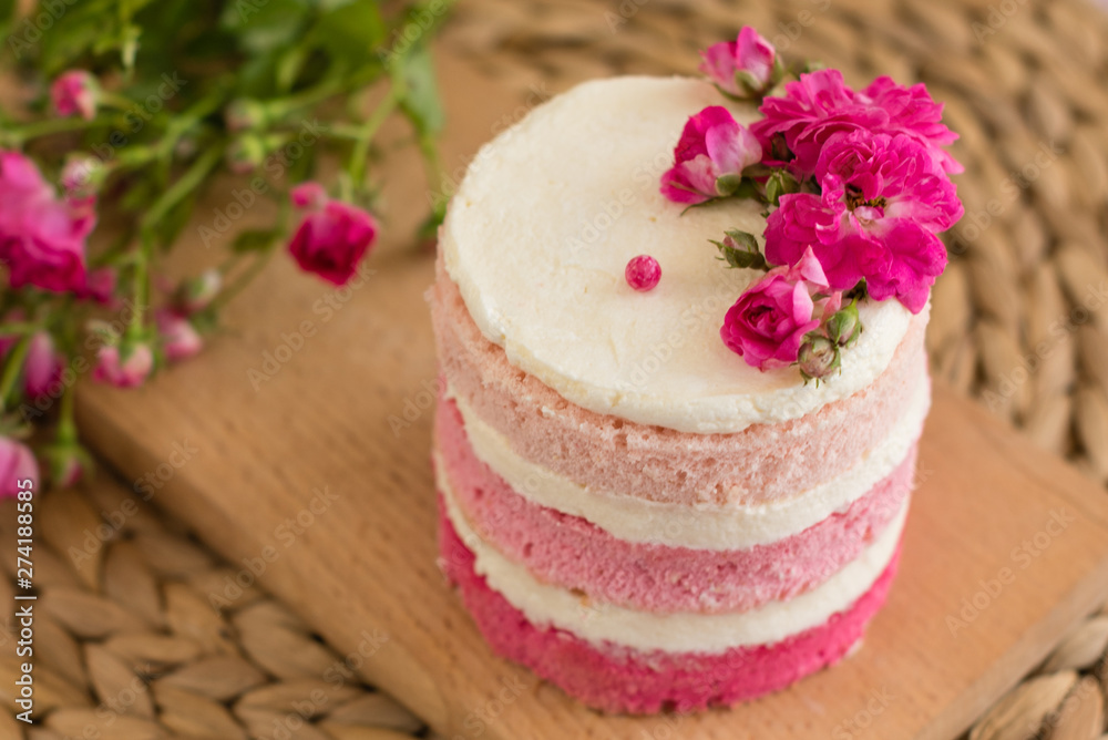 Beautiful pink cream and berries cake on a light concrete background. Birthday celebration Beautiful pink cream and berries cake on a light concrete background. Birthday celebration