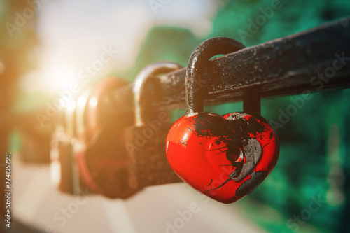 Many love padlocks locked on iron railing on a blurred background. Tourists place. Love sign and romance concept.