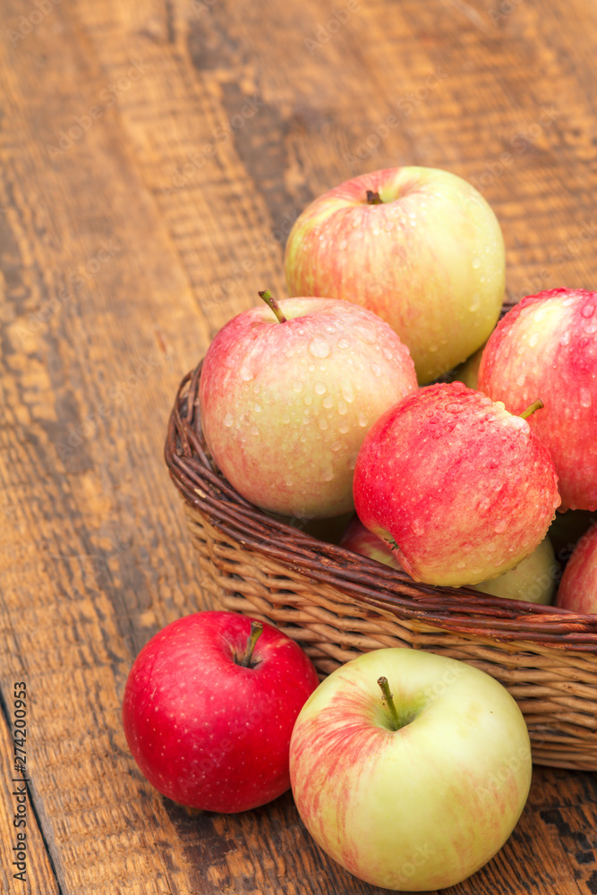Red apples in wicker basket on wooden boards Red apples in wicker basket on wooden boards