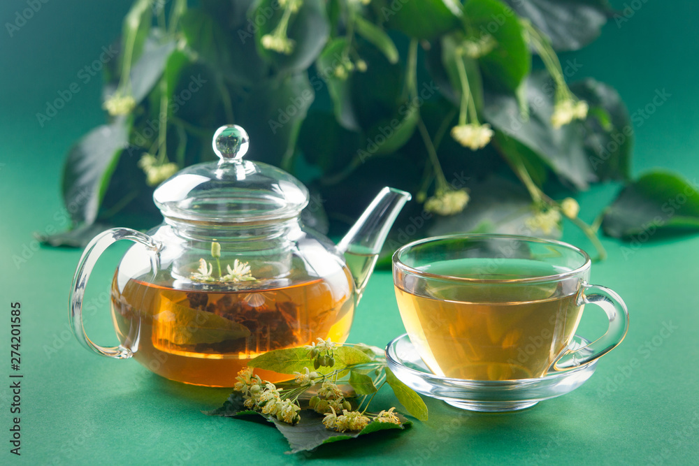 linden tea on the background of flowers and leaves of linden. Side view. Soft focus linden tea on the background of flowers and leaves of linden. Side view. Soft focus