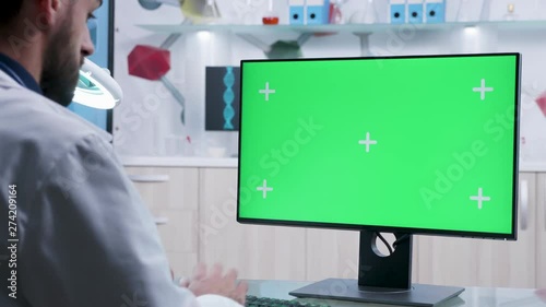 Researcher working on green screen mock-up PC in modern laboratory. Easily replace the mock up