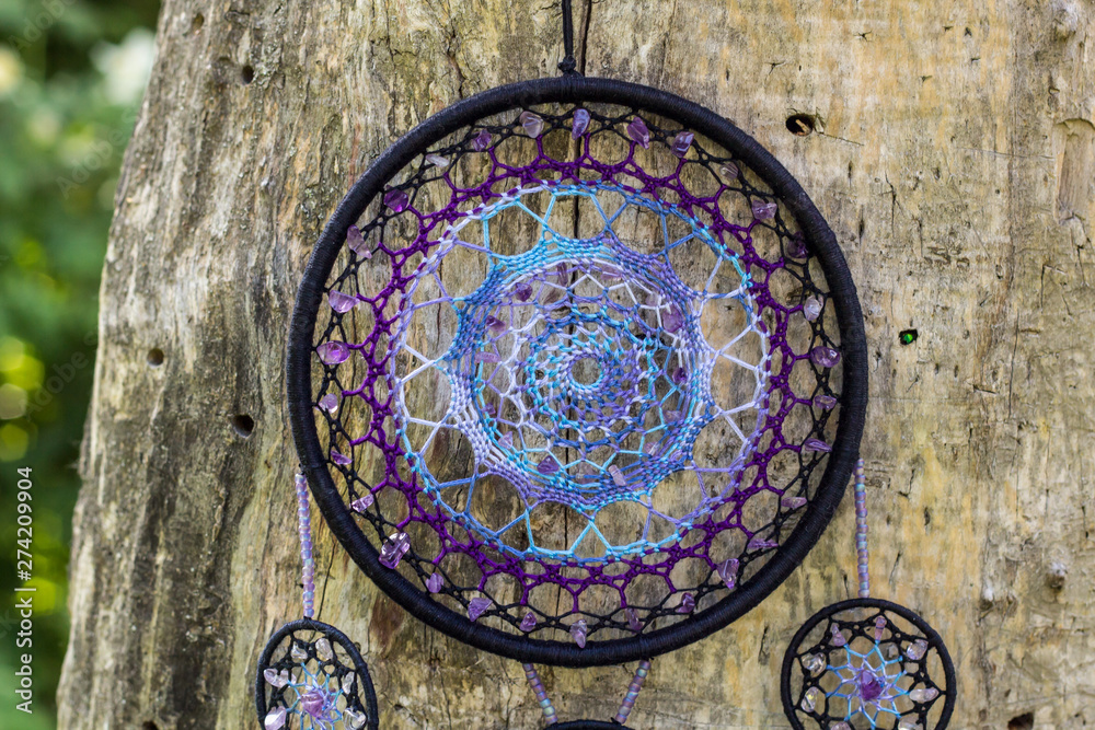 Fototapeta premium Handmade dream catcher with feathers threads and beads rope hanging