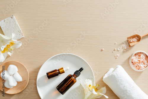 Spa still life top view with flowers, natural oil, bath salth and towels, spa skincare products,pumice stone photo