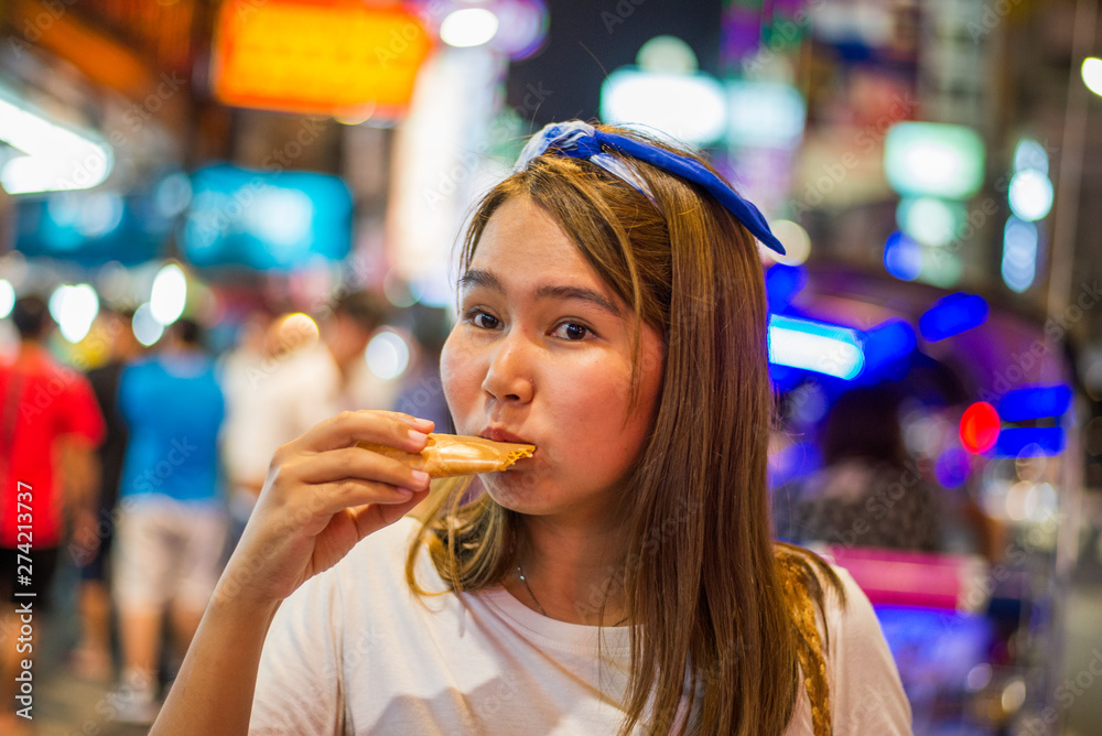 Asian young woman travel in China town at Thailand at Night,Woman travel and eating Night street food market at Yaowarat road, China town Bangkok, Thailand Asian young woman travel in China town at Thailand at Night,Woman travel and eating Night street food market at Yaowarat road, China town Bangkok, Thailand