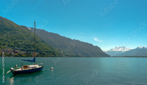 sailboat on the shores of Lake Geneva with great view of the Swiss Alps behind as seen from the Montreux Riviera