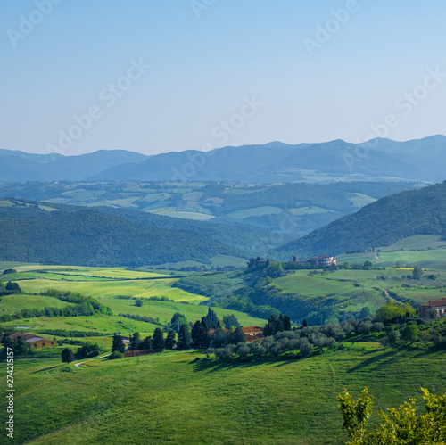 Typical Tuscany landscape with hills, green trees and houses, Italy.