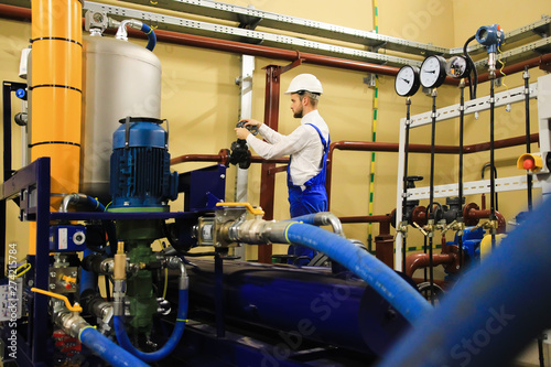 Mechanical inspector turning gate valve on oil and gas factory.