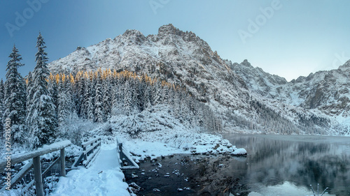 Fototapeta Naklejka Na Ścianę i Meble -  Winter. Ice mountain lake in rocky snowy mountains. Winter nature landscape. Scenery mountains and icy lake