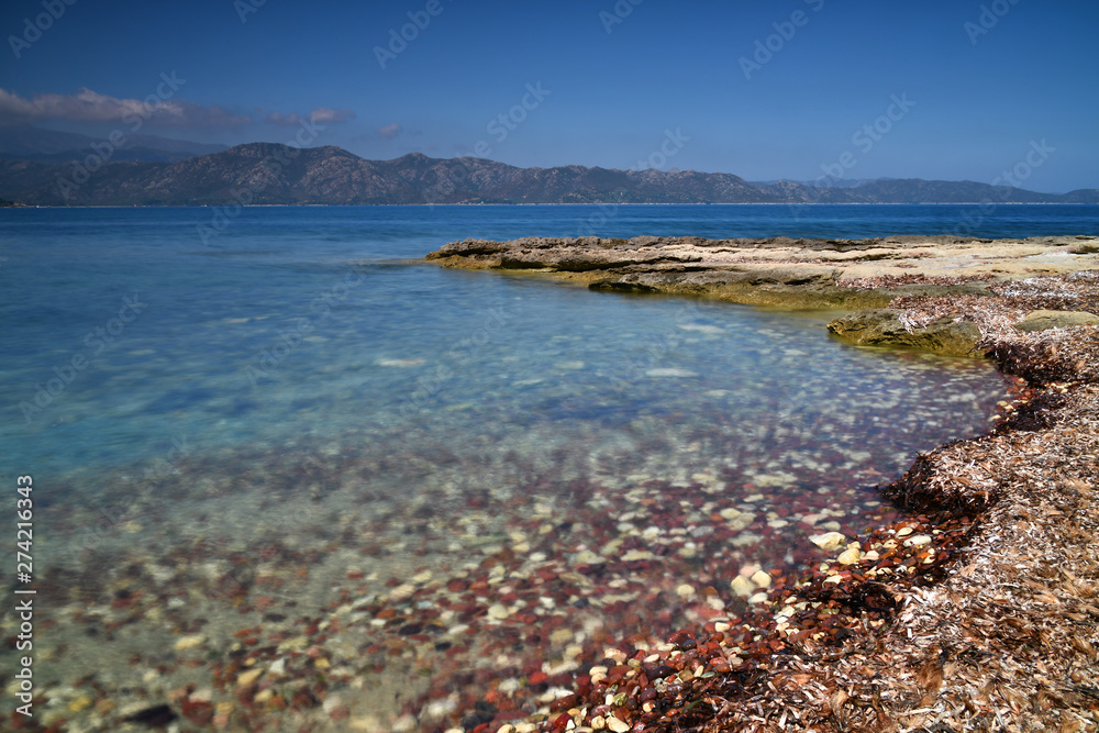 Stones, sea and blue sky in the North of Corsica during a summer vacation