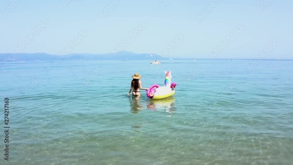 Corfu island - Walking girl with unicorn toy Corfu island - Walking girl with unicorn toy