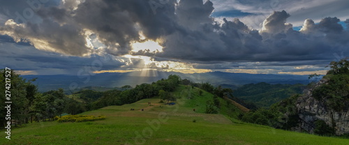 Panorama sunset at Doi Samur Dao, mountain view evening of dark clouds moving with sun-rays and raining above the hill, Sri Nan National Park, Nan, northern of Thailand. photo