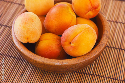 Organic apricots in a wooden bowl