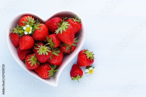 Strawberry heart. Fresh strawberries in plate on white wooden table. Top view  copy space.