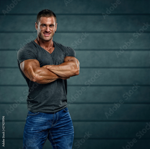 Handsome Bodybuilder Wearing T-shirt and Jeans Posing
