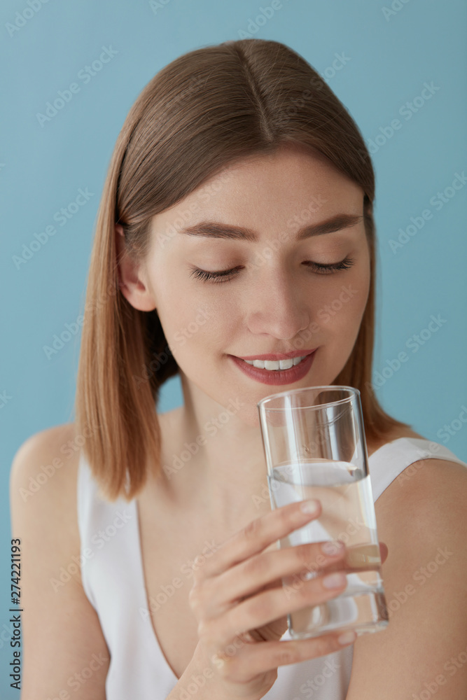 Drink water. Smiling woman drinking water from glass portrait Drink water. Smiling woman drinking water from glass portrait