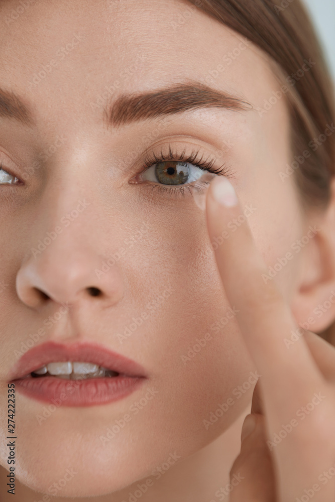 Contact eye lens. Woman applying eye contacts on eyes closeup Contact eye lens. Woman applying eye contacts on eyes closeup