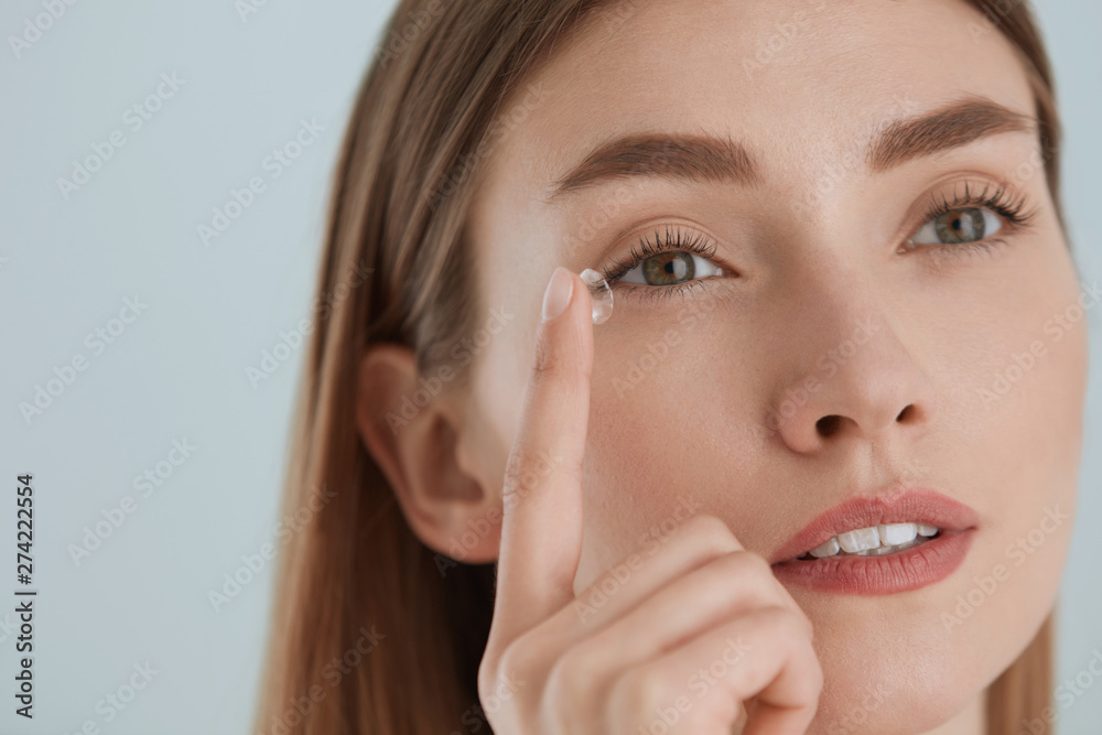 Contact eye lens. Woman applying eye contacts on eyes closeup Contact eye lens. Woman applying eye contacts on eyes closeup