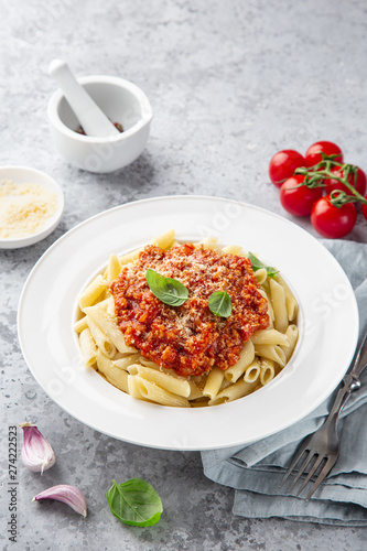 penne pasta with Bolognese sause and parmesan cheese in white plate