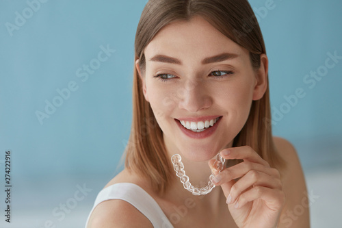 Photography Teeth whitening. Woman with healthy teeth using removable braces