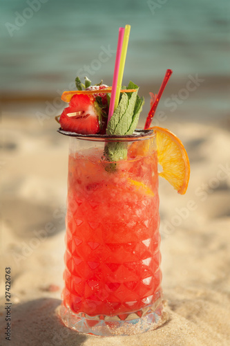Red Cocktail Sex On The Beach against the sea. Warm toning