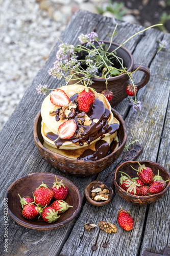 Fototapeta Naklejka Na Ścianę i Meble -  pancakes with chocolate and fresh strawberries in a rustic style on a wooden background