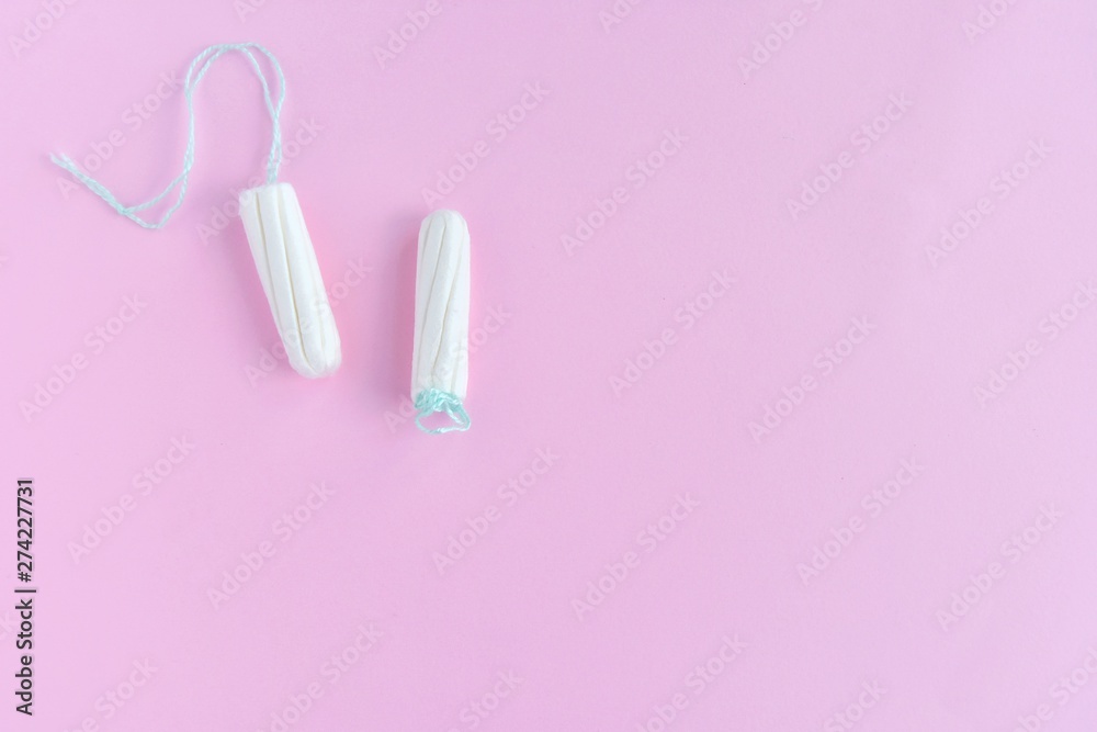 Two cotton tampons for women monthly menstruation with selective focus on blurred pink background. Soft white tampon for female period days on neutral backdrop with empty space for text. Healthcare Two cotton tampons for women monthly menstruation with selective focus on blurred pink background. Soft white tampon for female period days on neutral backdrop with empty space for text. Healthcare