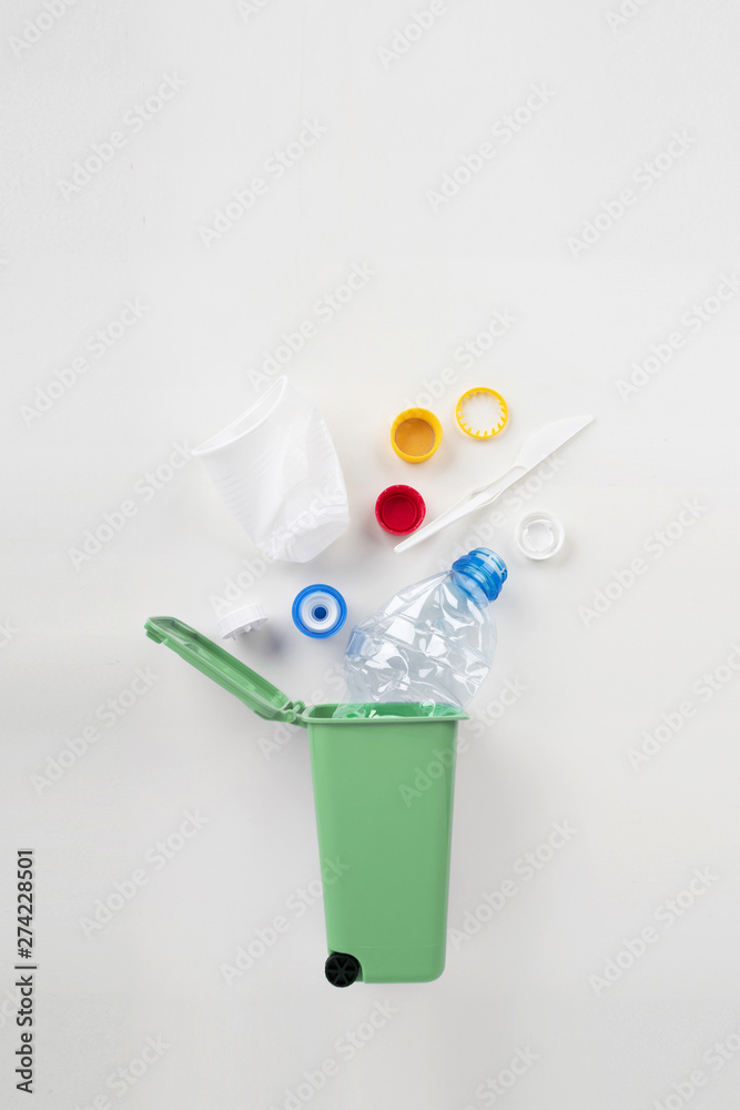 Trash bin with plastic waste on a gray background. Recycling concept