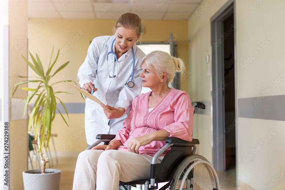 Senior woman in wheelchair with nurse in hospital Senior woman in wheelchair with nurse in hospital