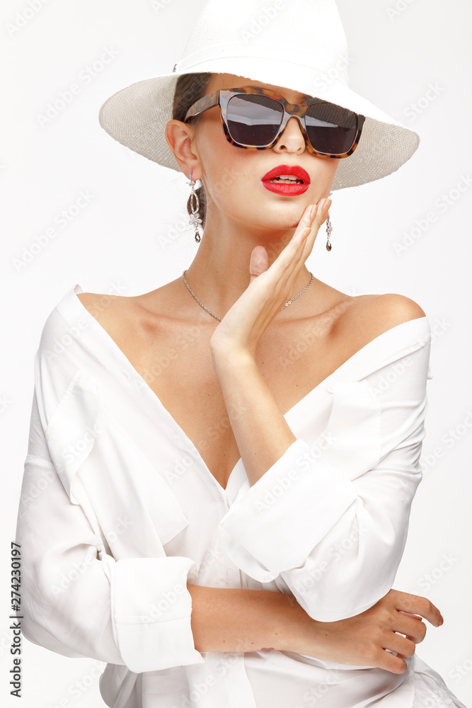 Beautiful girl in an elegant white hat, sunglassess and exquisite jewelry. Beautiful girl in an elegant white hat, sunglassess and exquisite jewelry.