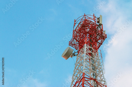 Wireless Communication Antenna Transmitter. Telecommunication tower with antennas on blue sky background.