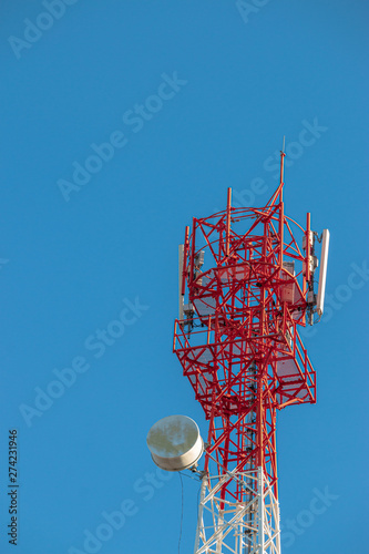 Wireless Communication Antenna Transmitter. Telecommunication tower with antennas on blue sky background.